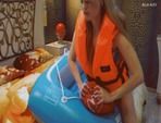 Alla Sit To Pop A Balloon By Sitting On An Inflatable Boat And Wearing A Life Vest.